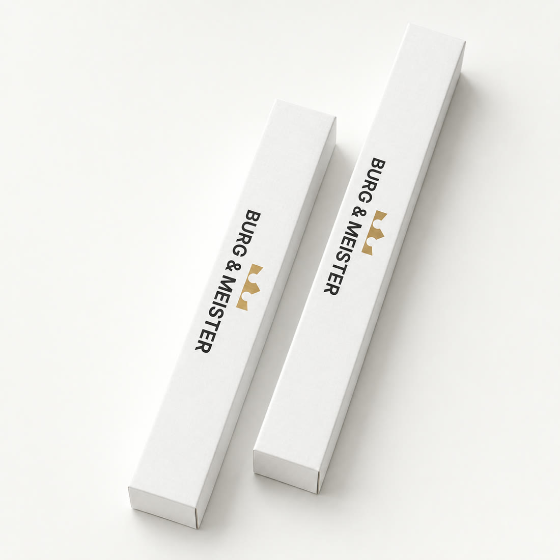 Zwei Produktverpackungen von Burg & Meister mit schwarzer Wortmarke und goldener Krone auf hellem Grund